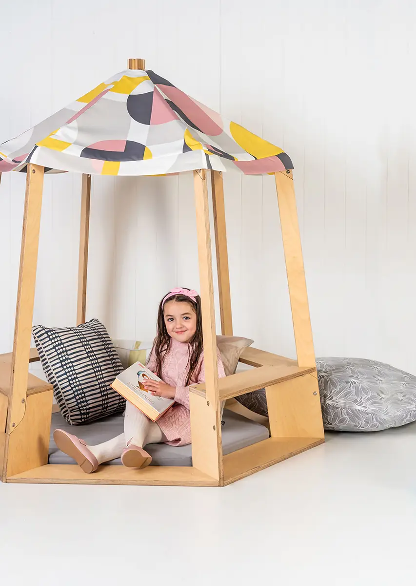 Girl sitting in tipi reading nook